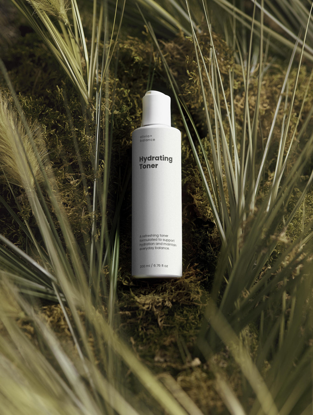 Bottle of Hydrating Toner surrounded by grass and plants