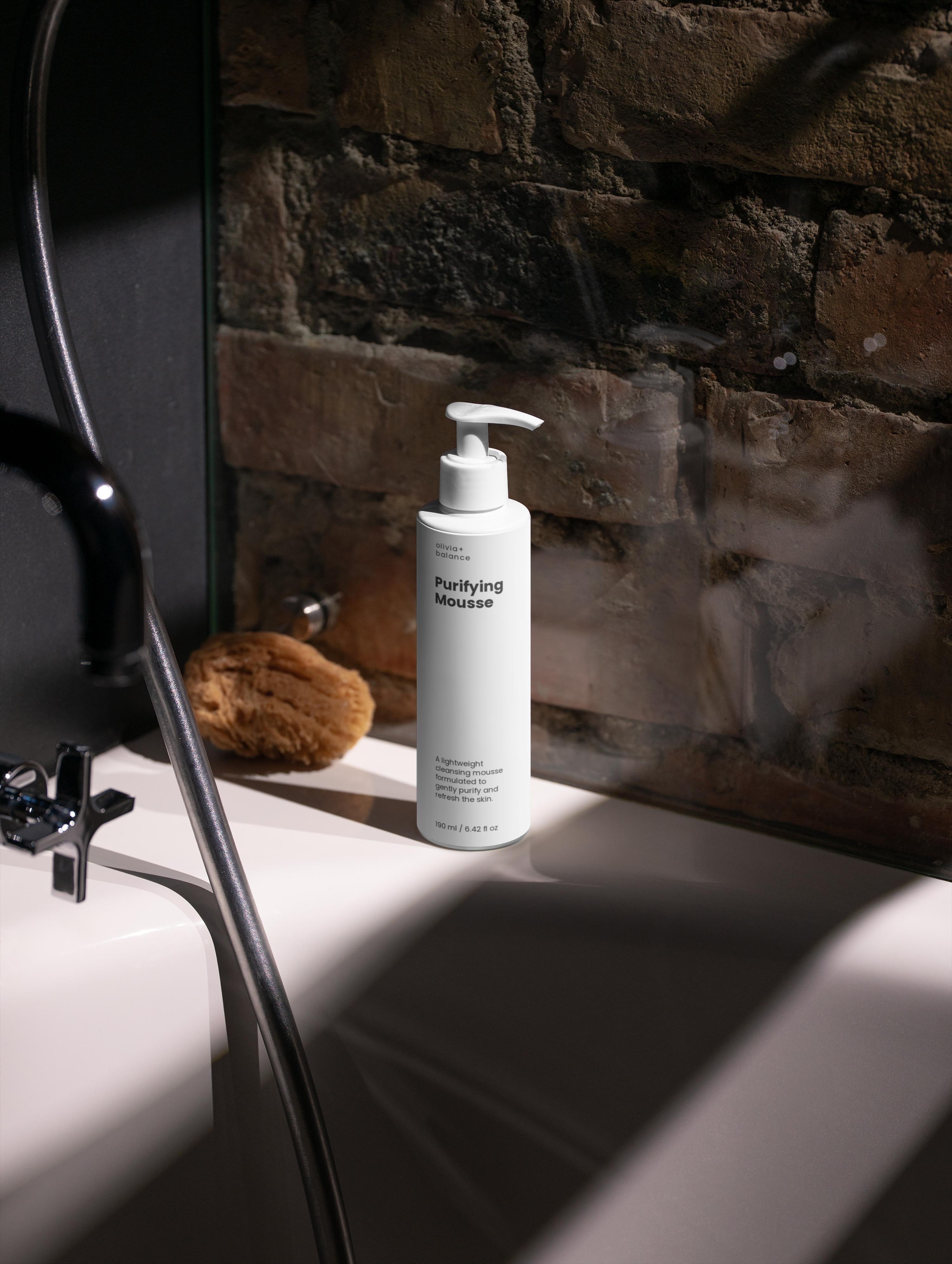 White bottle with pump on a bathroom counter against a brick wall.
