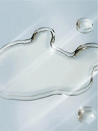 Close-up of silver liquid droplets on a light blue background