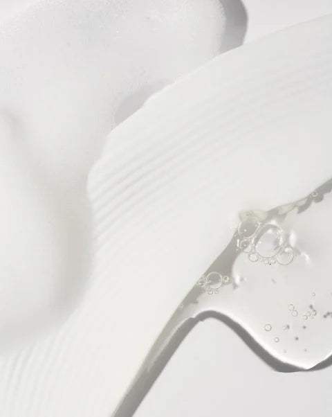 Close-up of a glass with a clear liquid on a light gray background