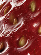 Close-up of a watermelon with seeds inside, showing red flesh and green seeds.