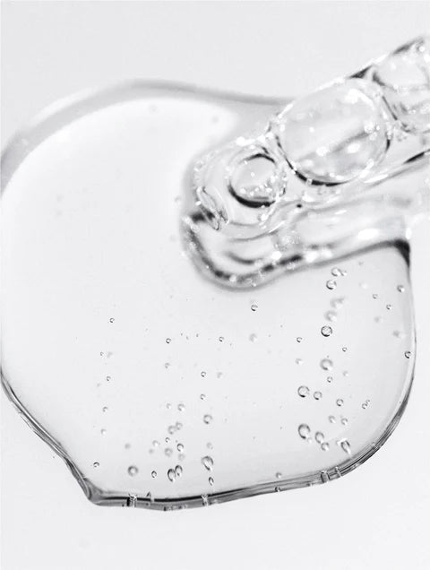 Heart-shaped glass object with water droplets on a white background