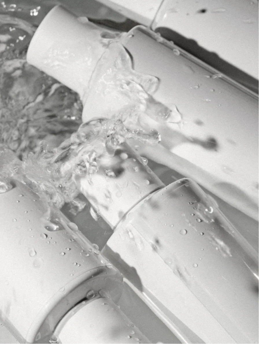 Close-up of a white plastic pipe with water flowing through it