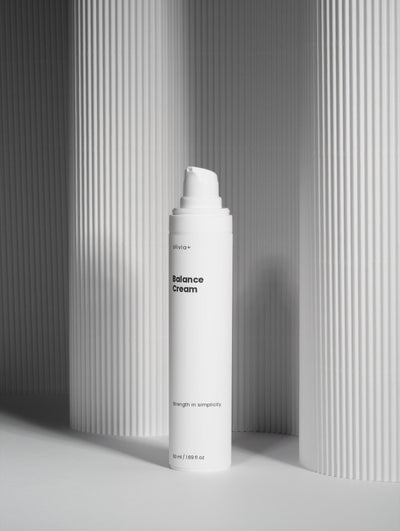 White cream bottle labeled 'Balance Cream' on a gray background