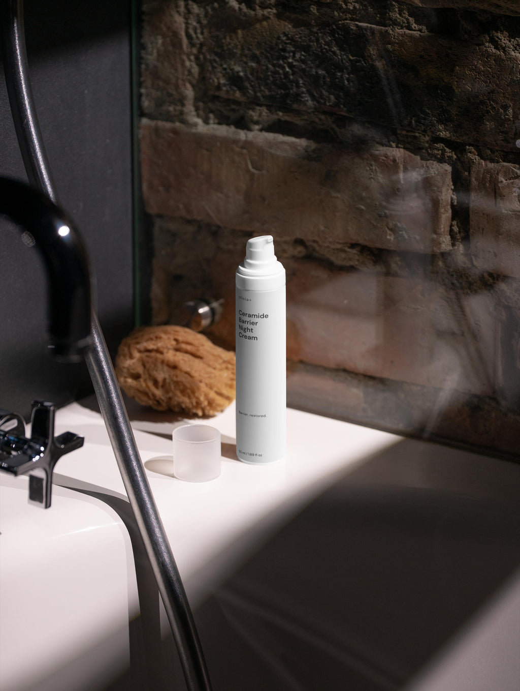 Skincare product on a bathroom counter with a stone wall background