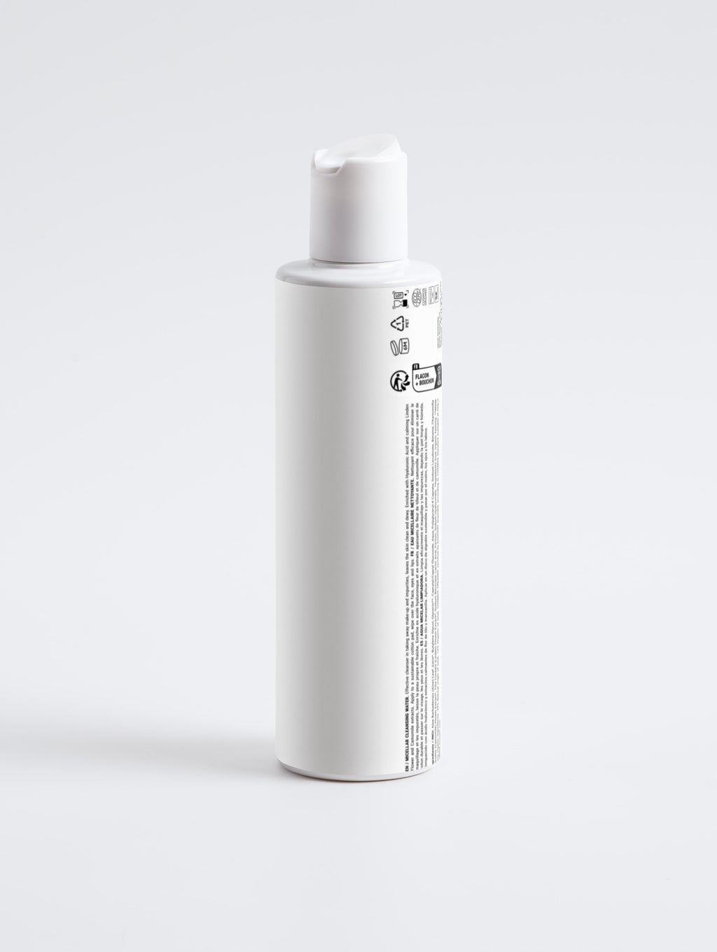 White bottle with a label on a light gray background